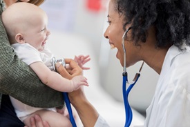 Baby laughing with doctor